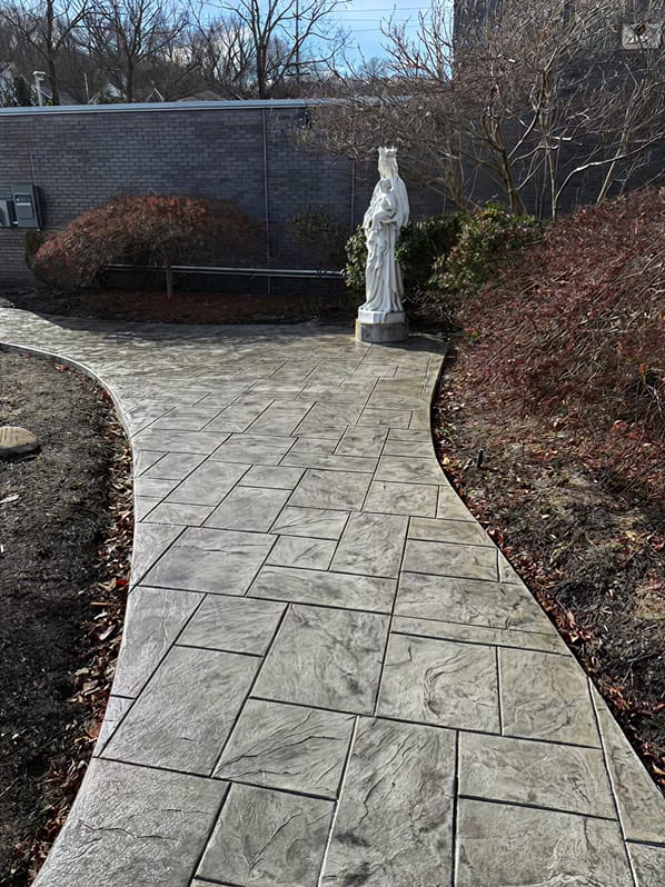 Stamped concrete walkway with natural stone pattern by Trademark Outdoor Services