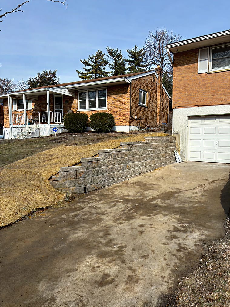 Segmental block retaining wall along driveway built by Trademark Outdoor Services